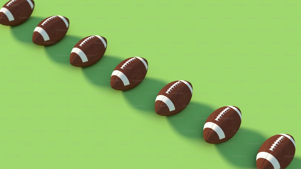 a row of chocolate footballs sitting on top of a green surface