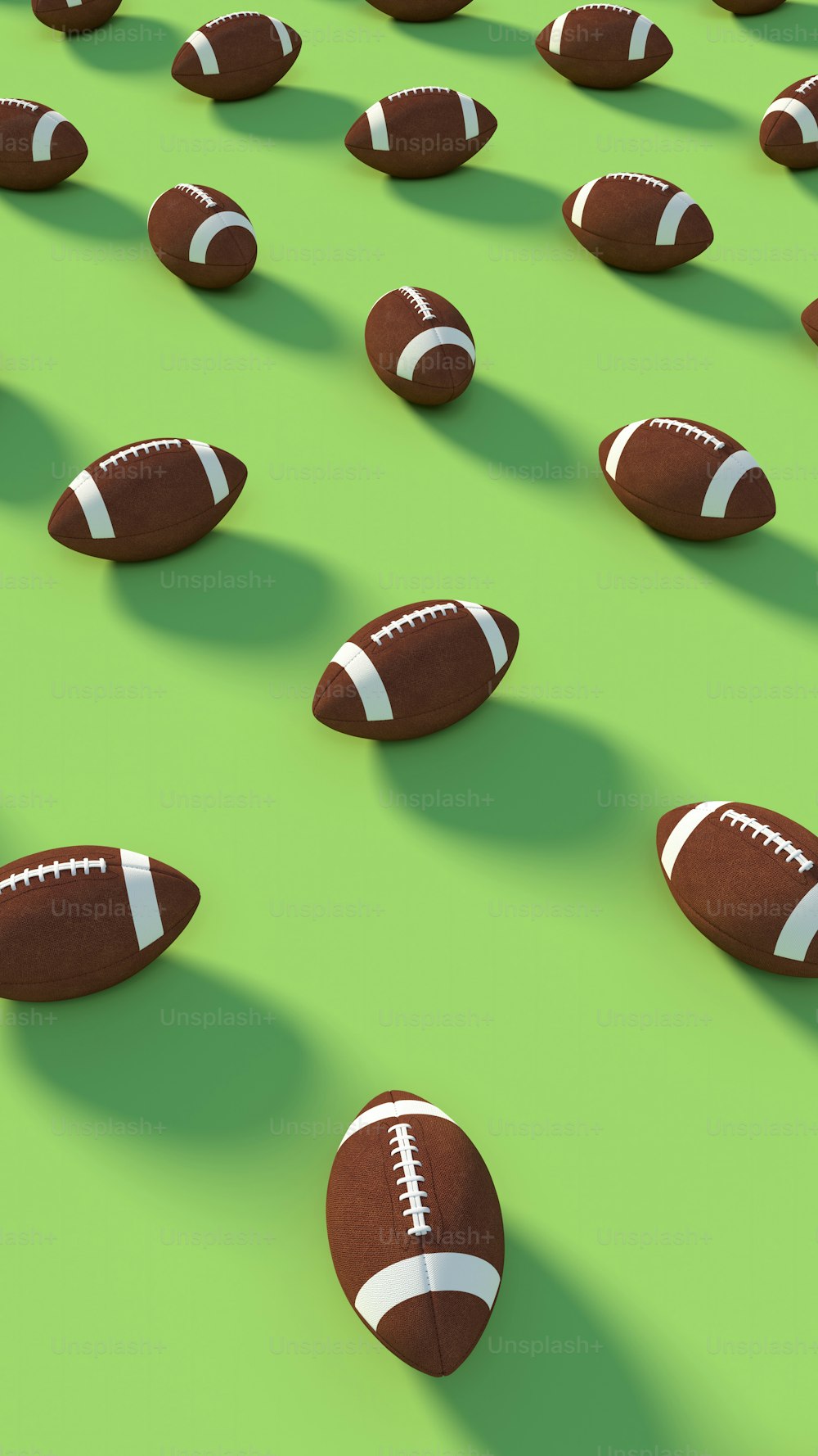 a group of footballs laying on top of a green field