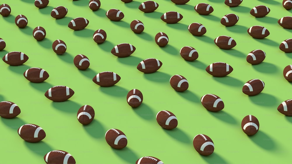 a large group of chocolate footballs on a green surface