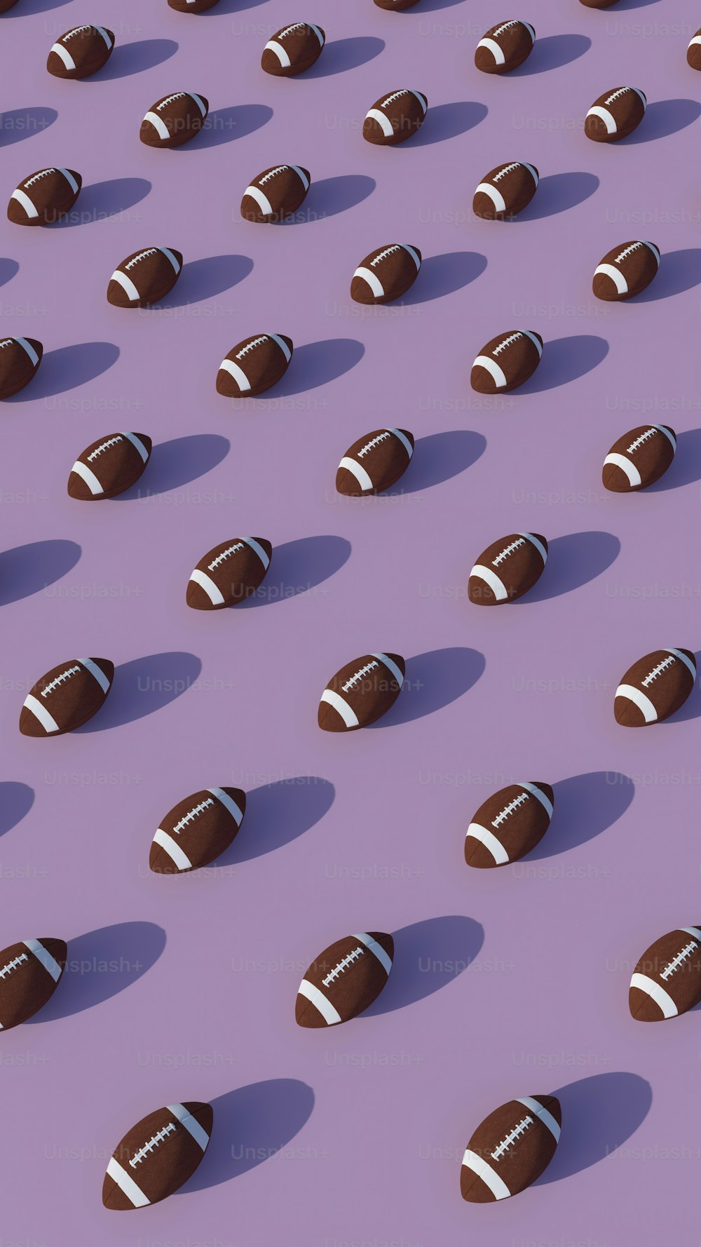 a group of footballs sitting on top of a purple surface