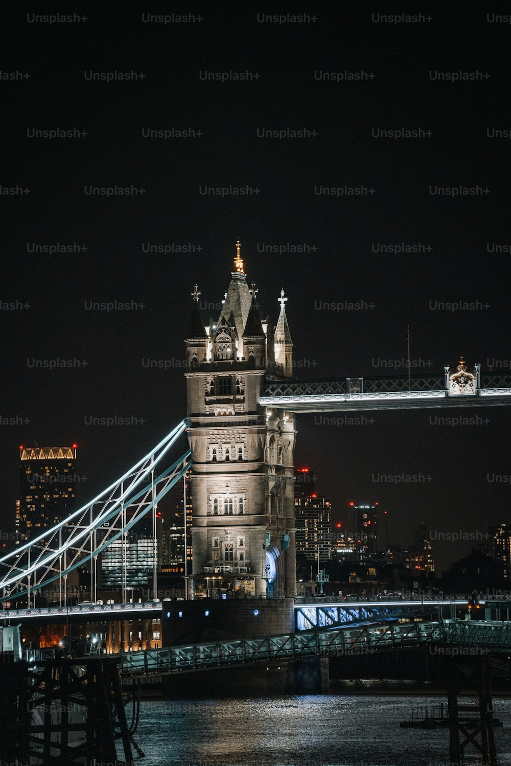 the tower bridge is lit up at night