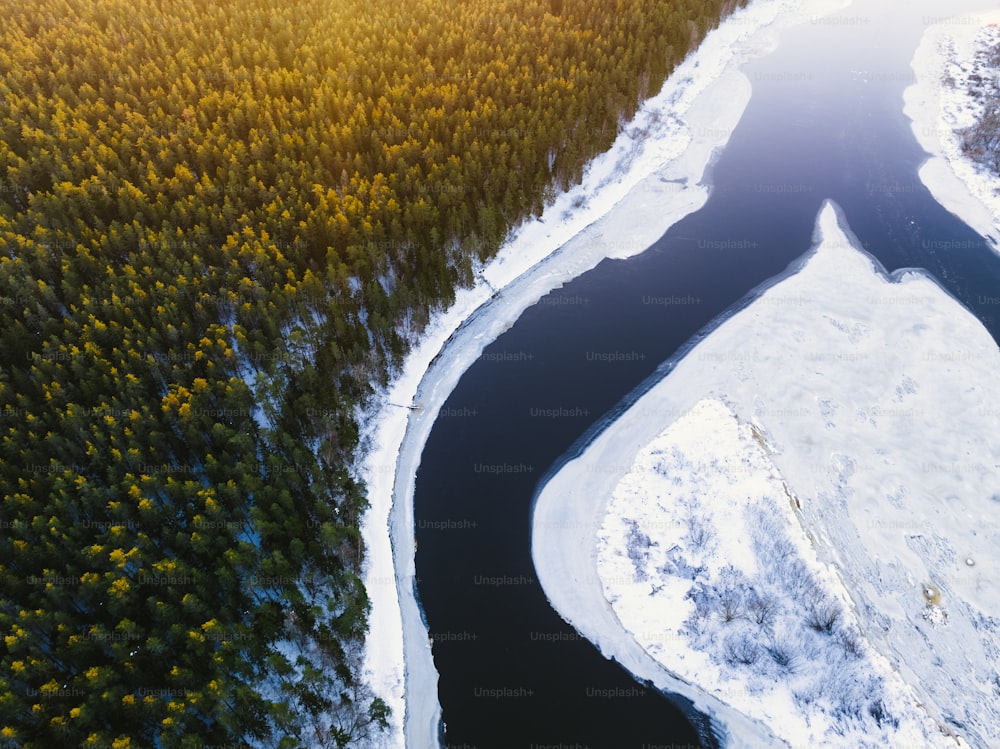 Ein Fluss, der durch einen schneebedeckten Wald fließt