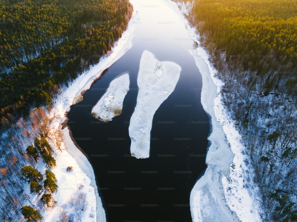 an aerial view of a river surrounded by snow