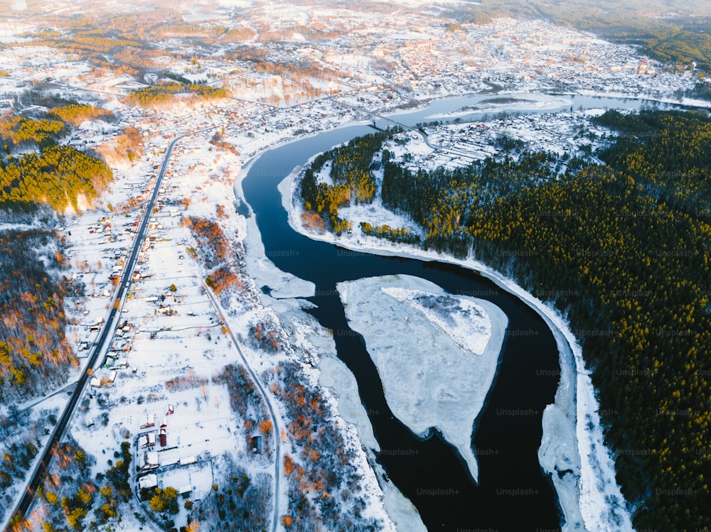 an aerial view of a river in a snowy area