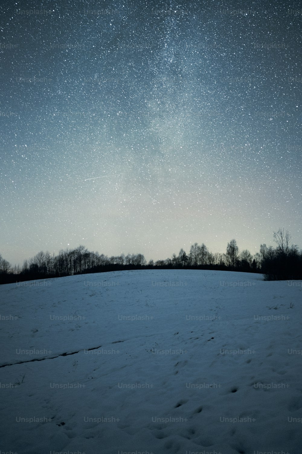 a field covered in snow under a night sky