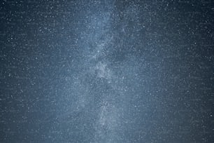 Un grupo de personas de pie bajo un cielo lleno de estrellas muy grande