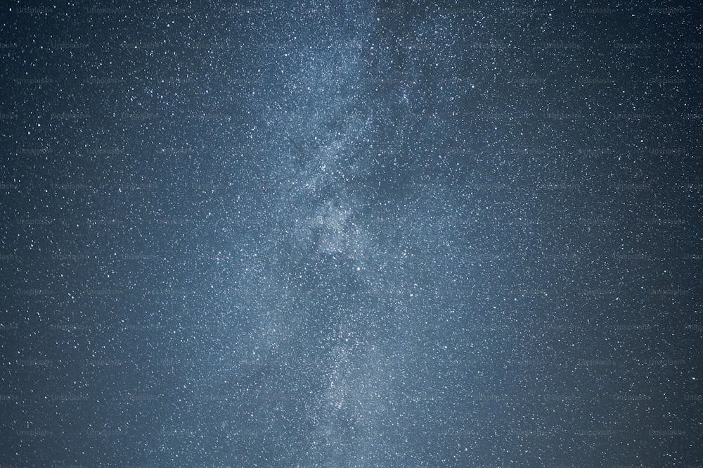 Un gruppo di persone in piedi sotto un cielo pieno di stelle molto grande