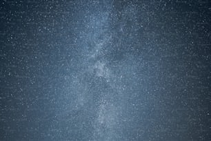 a group of people standing under a very large star filled sky