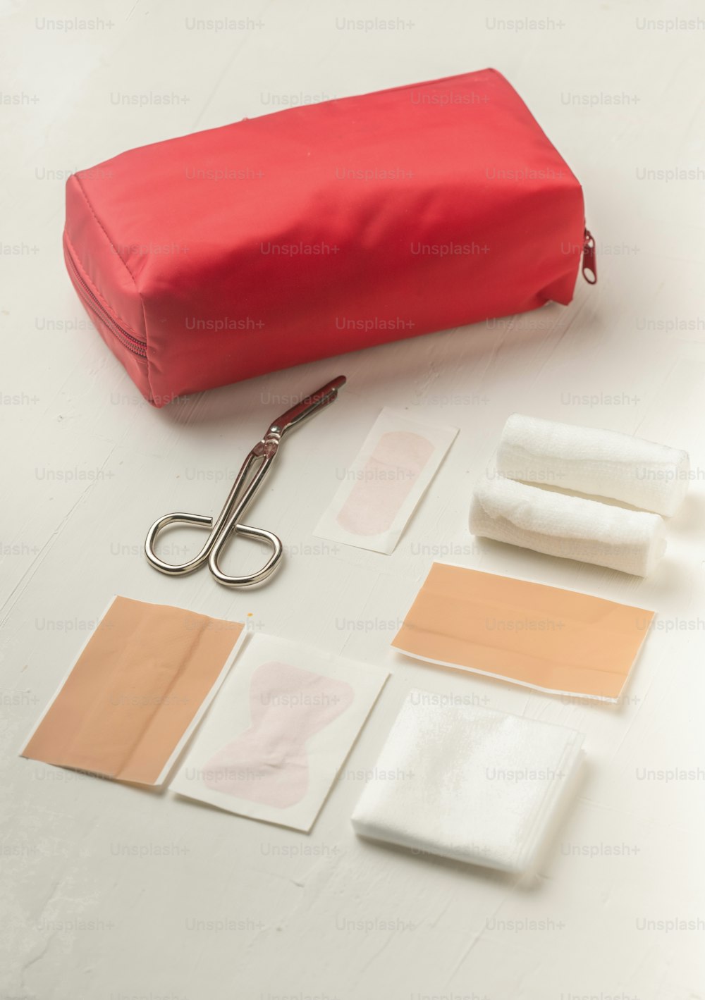 um saco vermelho sentado em cima de uma mesa ao lado de um par de tesouras