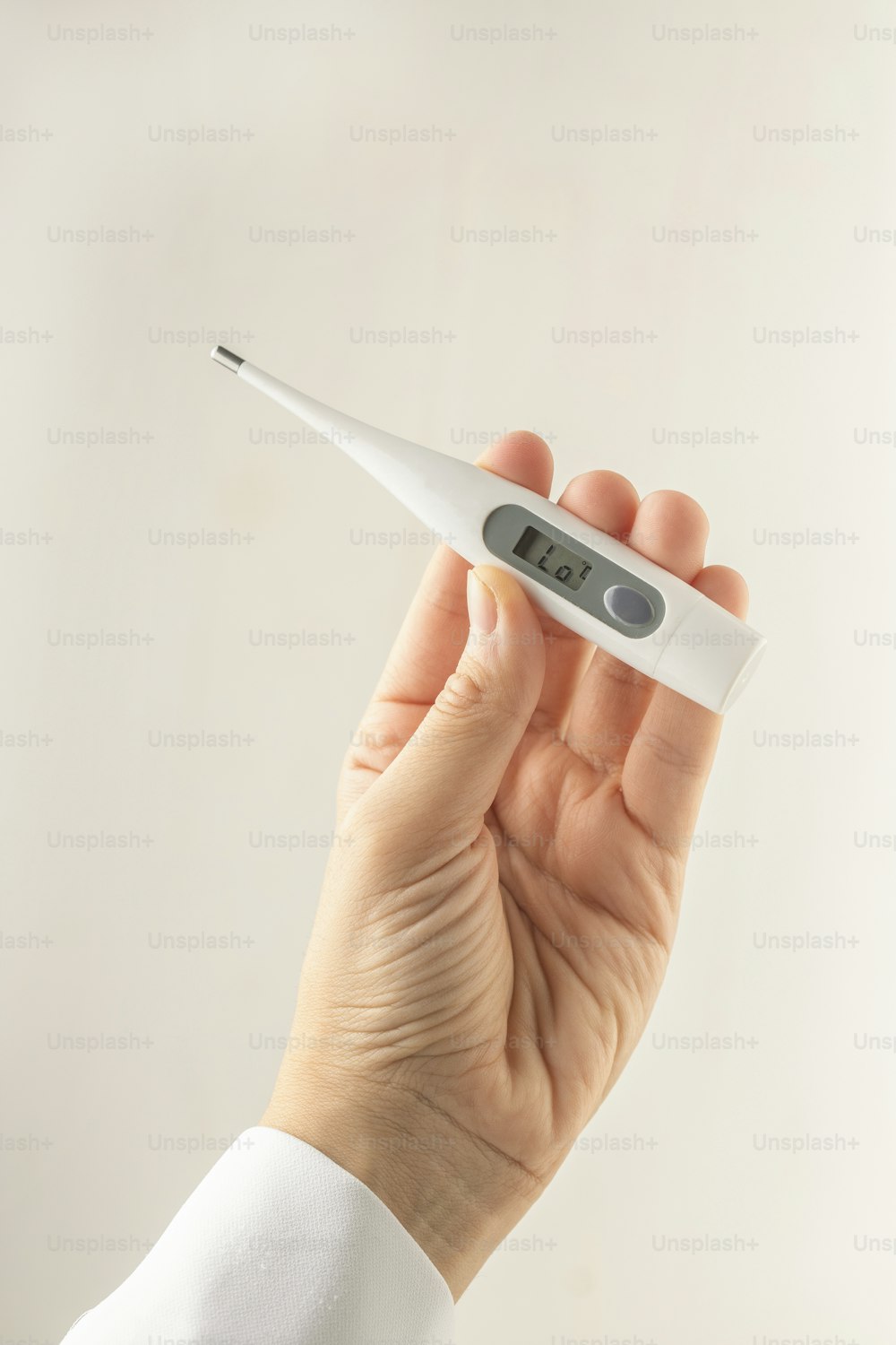 a person holding a thermometer in their hand