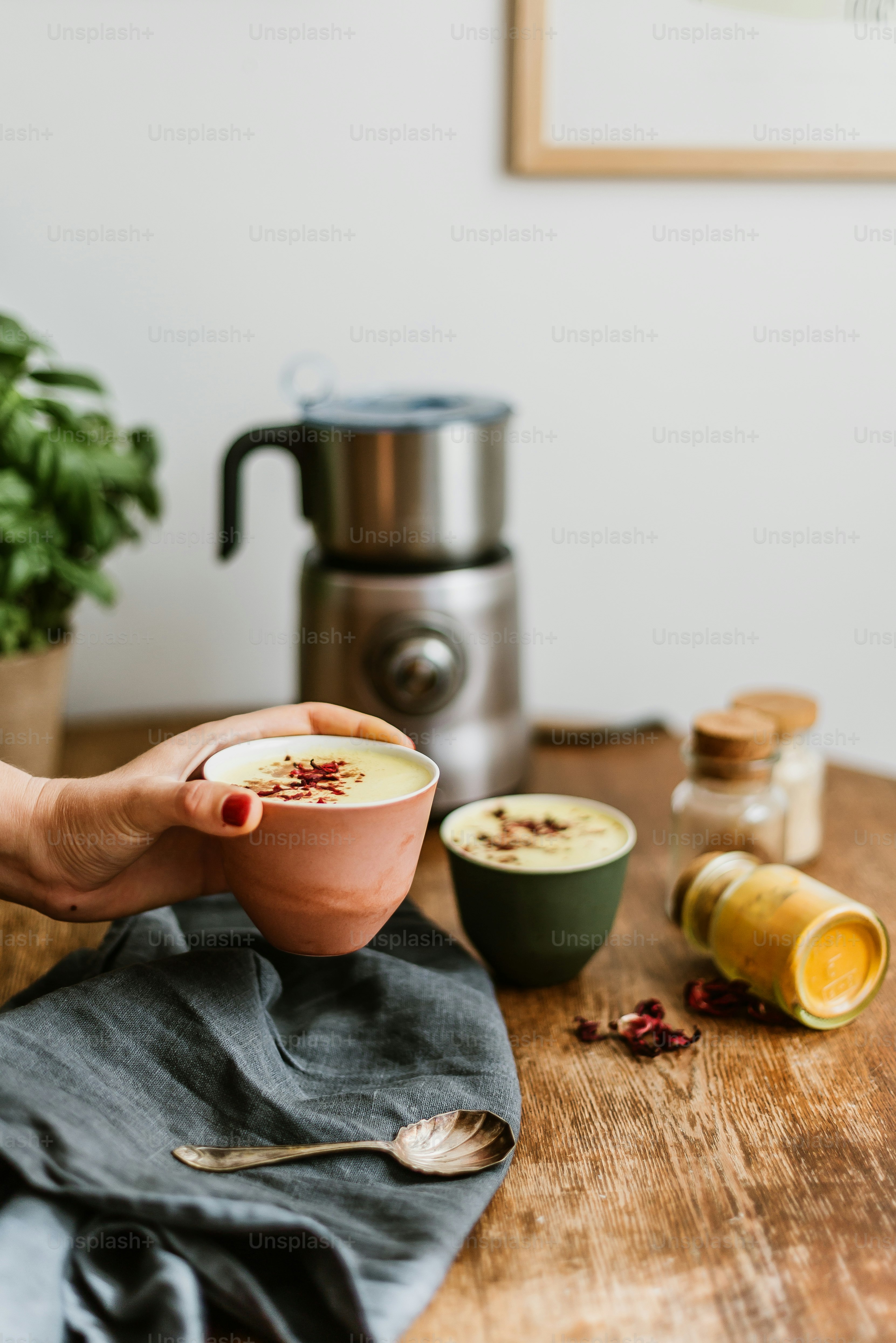 a person holding a bowl of food on top of a wooden table