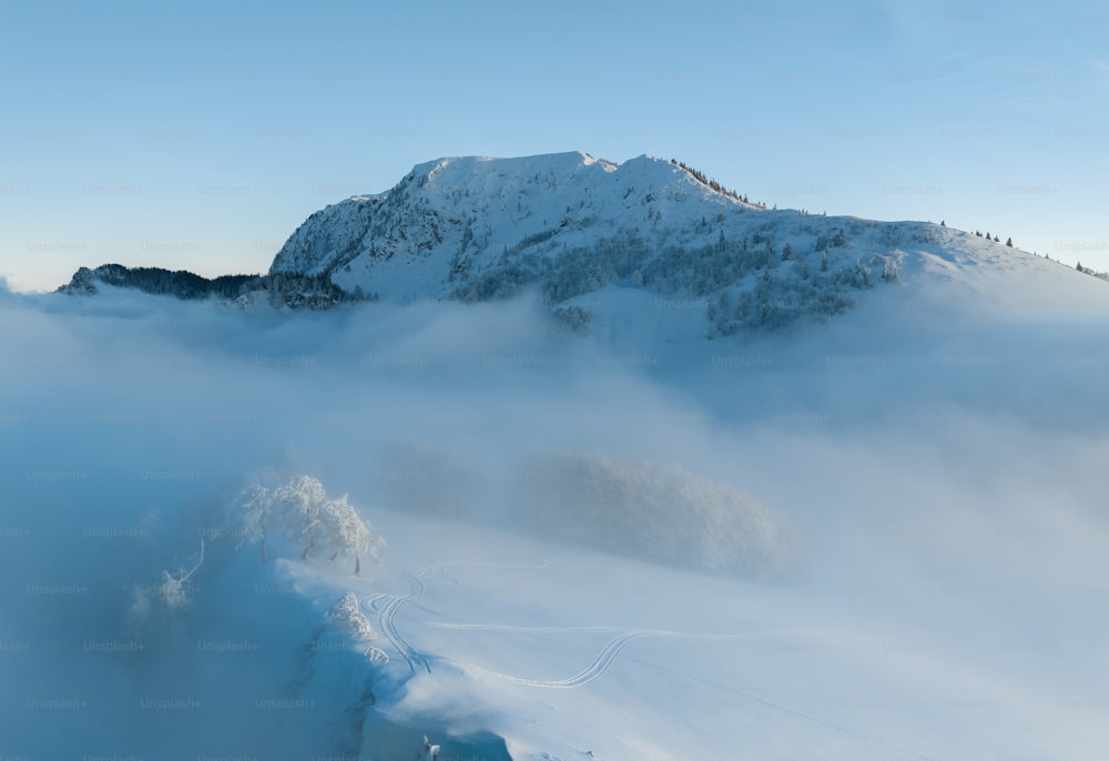 Una montagna coperta di neve e nuvole con uno sfondo del cielo
