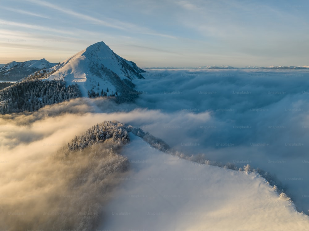 a mountain covered in snow and surrounded by clouds