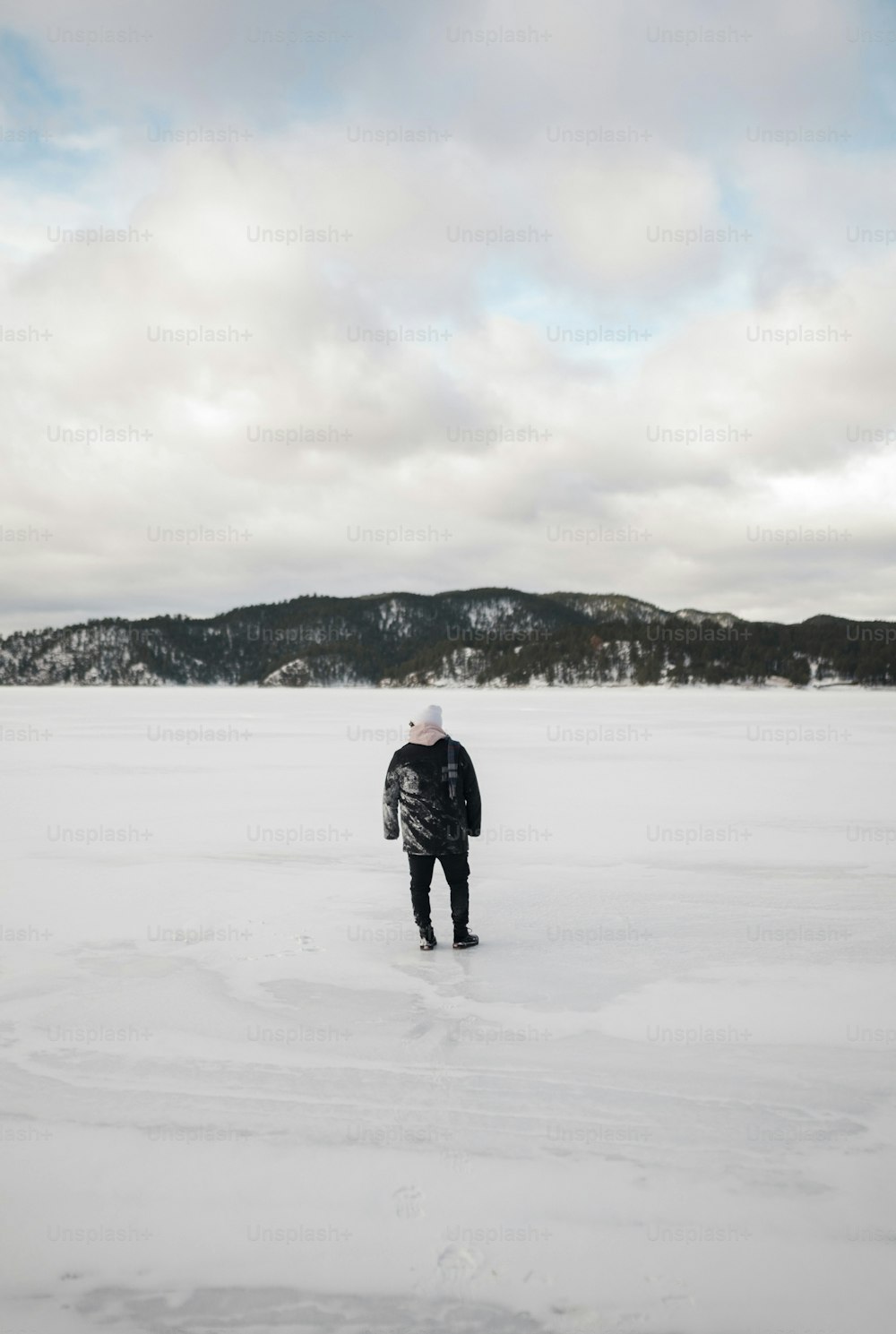a man walking across a snow covered field