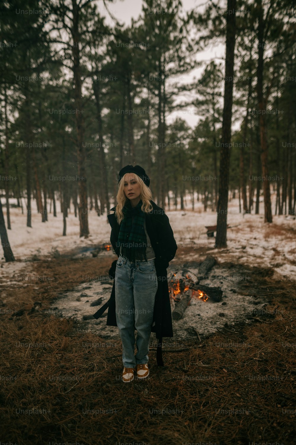 a woman standing in the middle of a forest