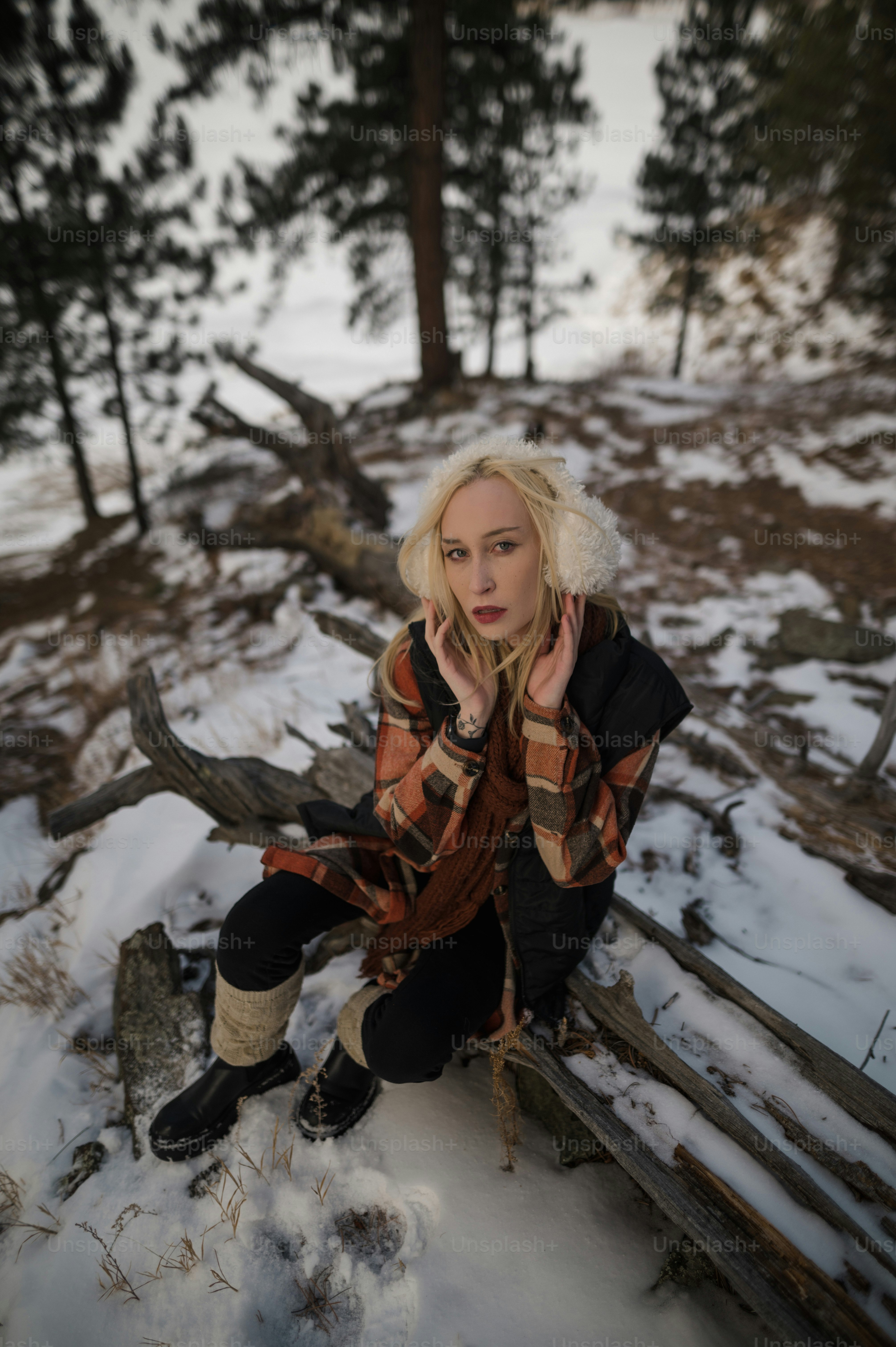 a woman sitting on a bench in the snow