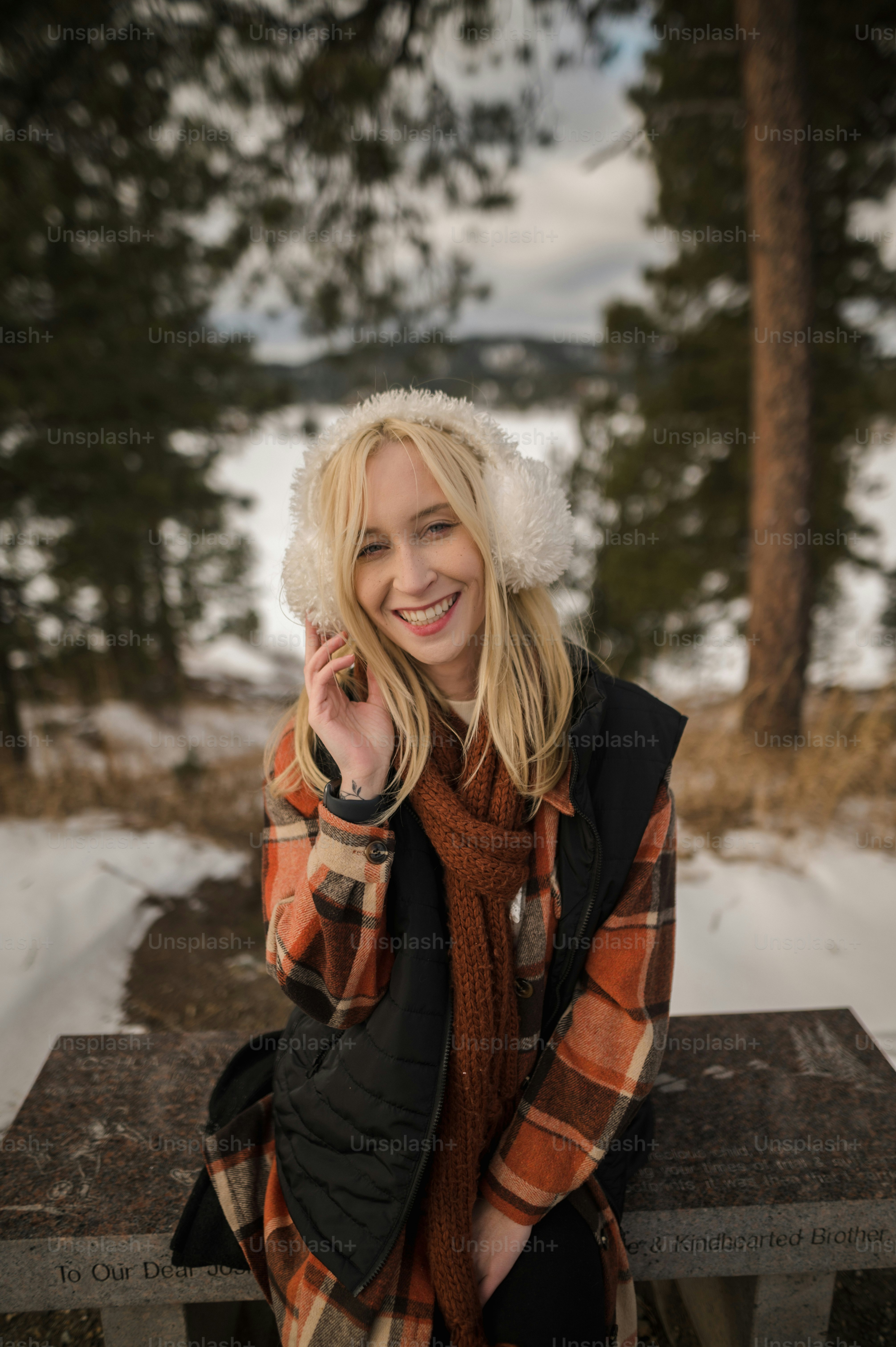 a woman sitting on a bench in the snow