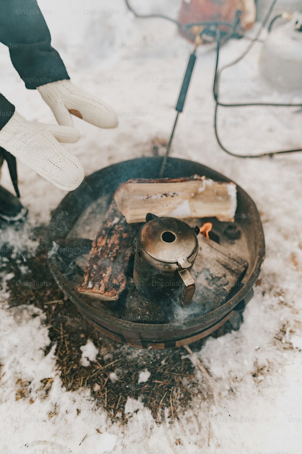 a person is cooking food on a stove in the snow
