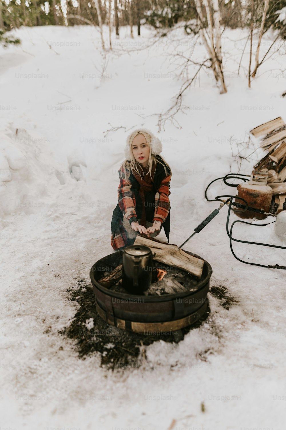 雪の中で樽の上に座っている女性