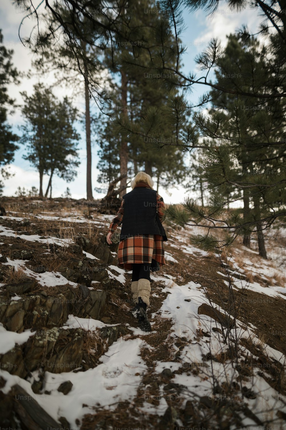 雪の中の森の中を歩く女性