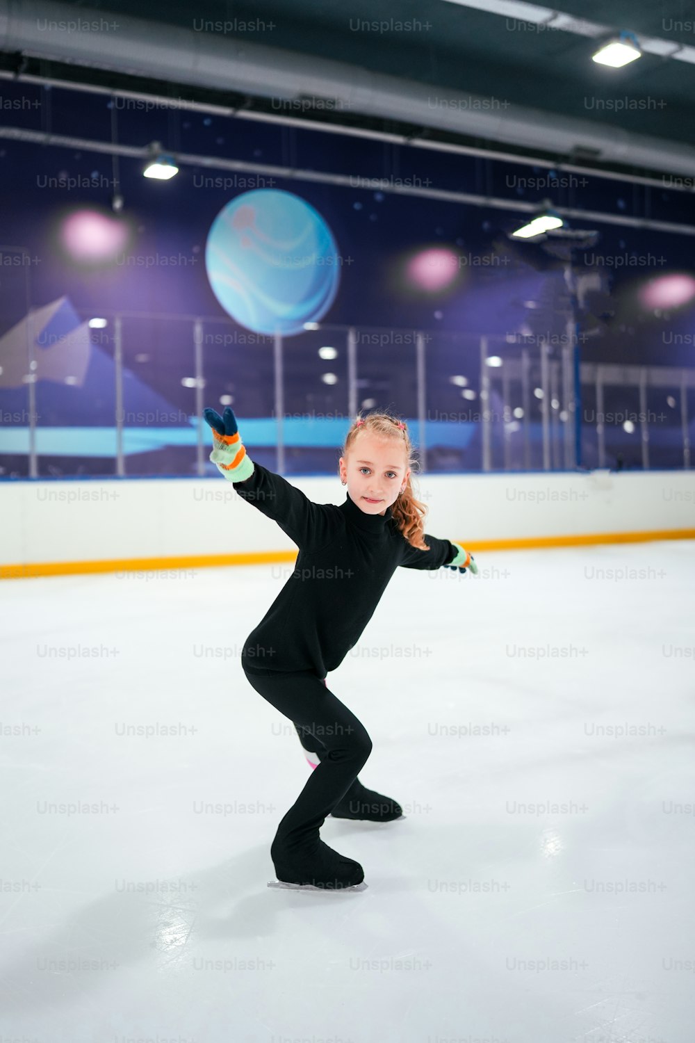 uma jovem que patina em uma pista de gelo