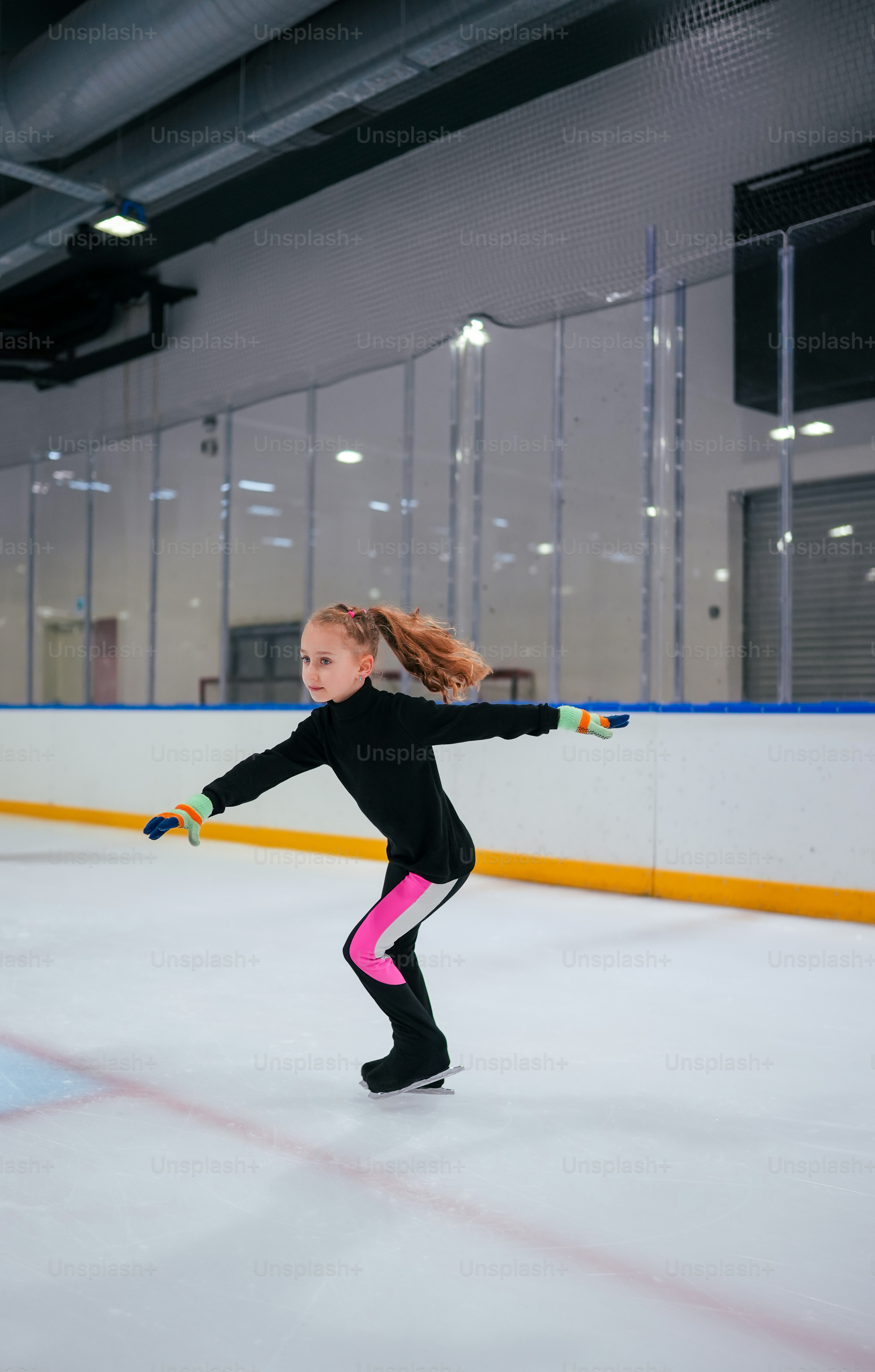 a young girl skating on an ice rink