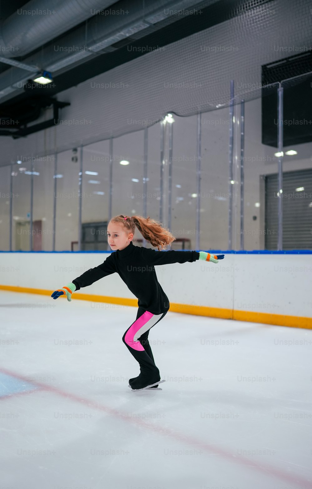 uma jovem que patina em uma pista de gelo