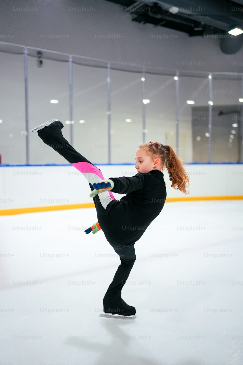 Ein junges Mädchen beim Eislaufen auf einer Eisbahn