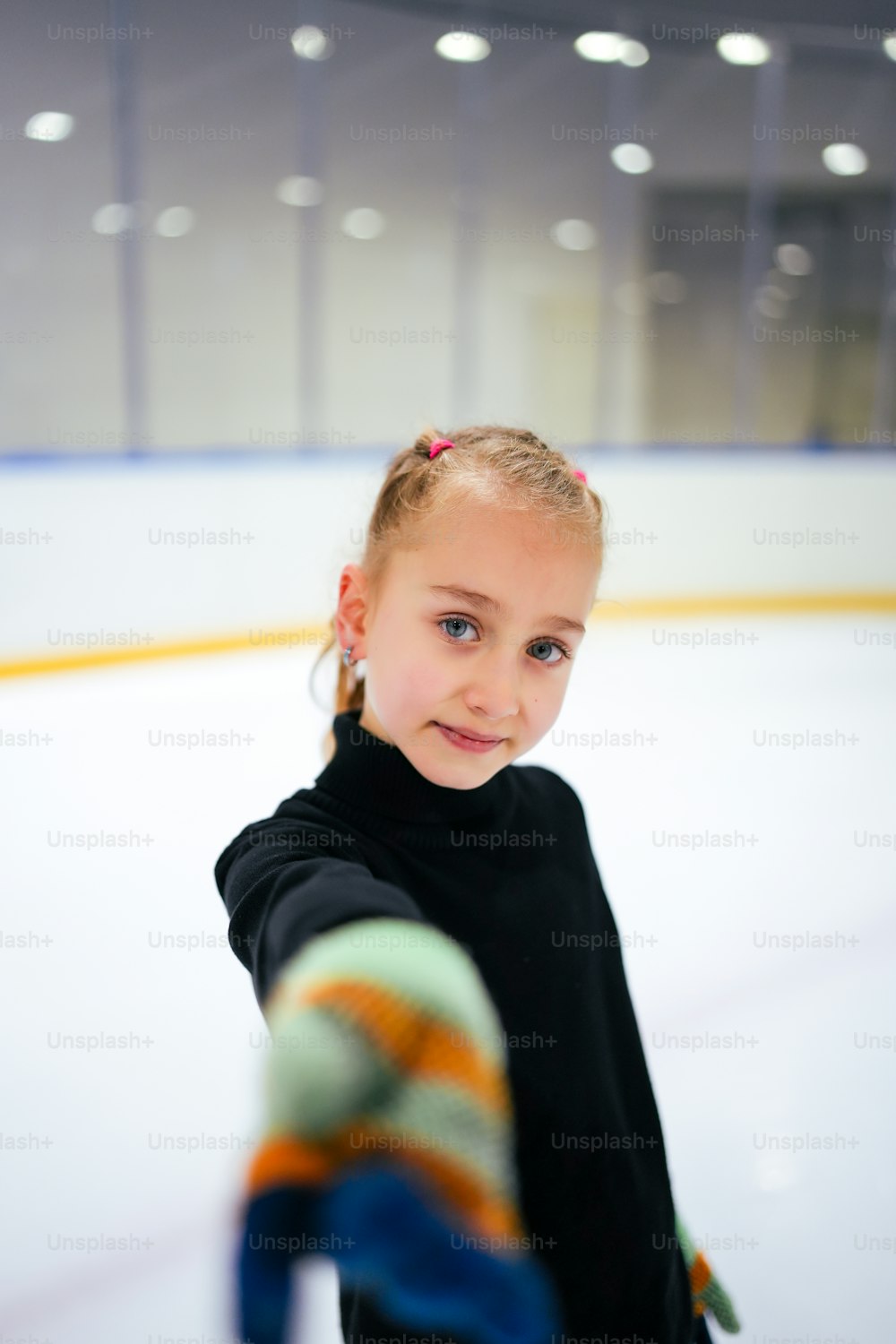 a young girl is standing on the ice