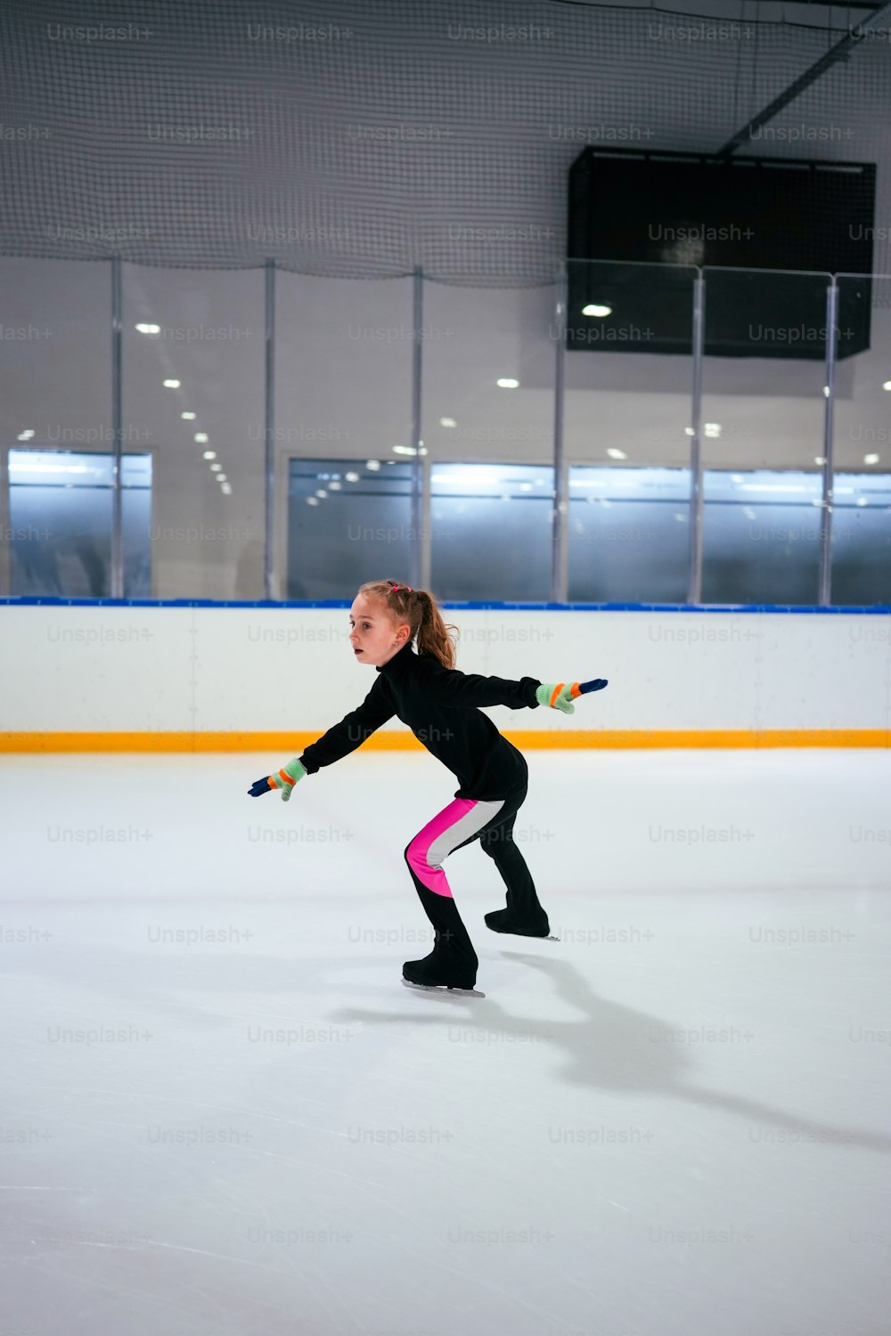 a young girl skating on an ice rink