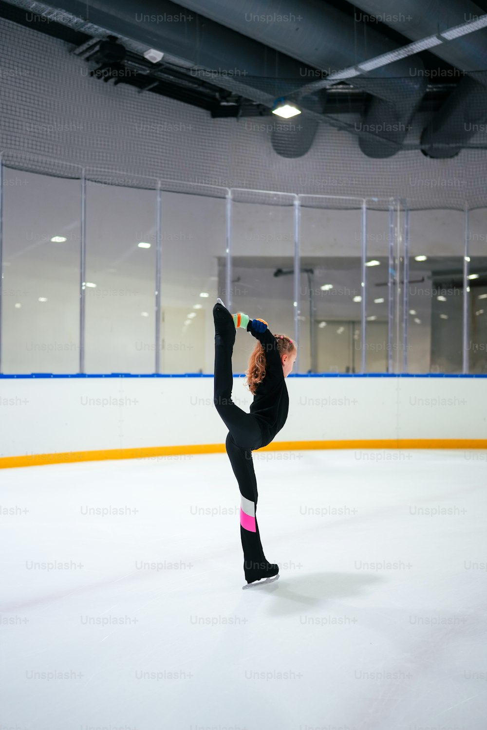uma mulher está fazendo um handstand em uma pista de gelo