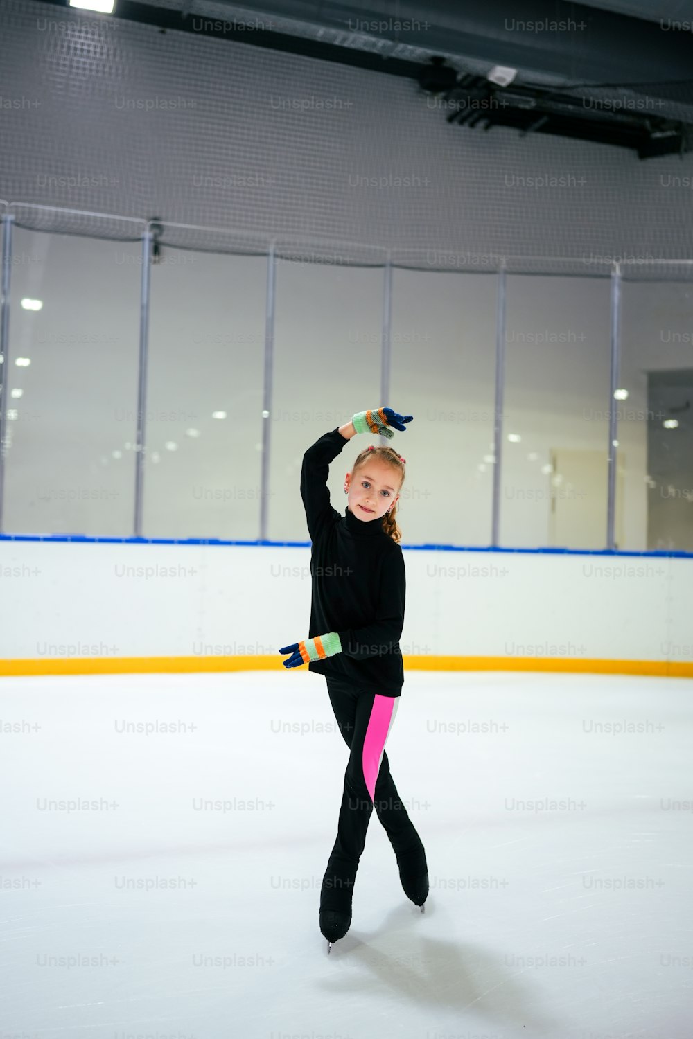 Ein junges Mädchen beim Eislaufen auf einer Eisbahn