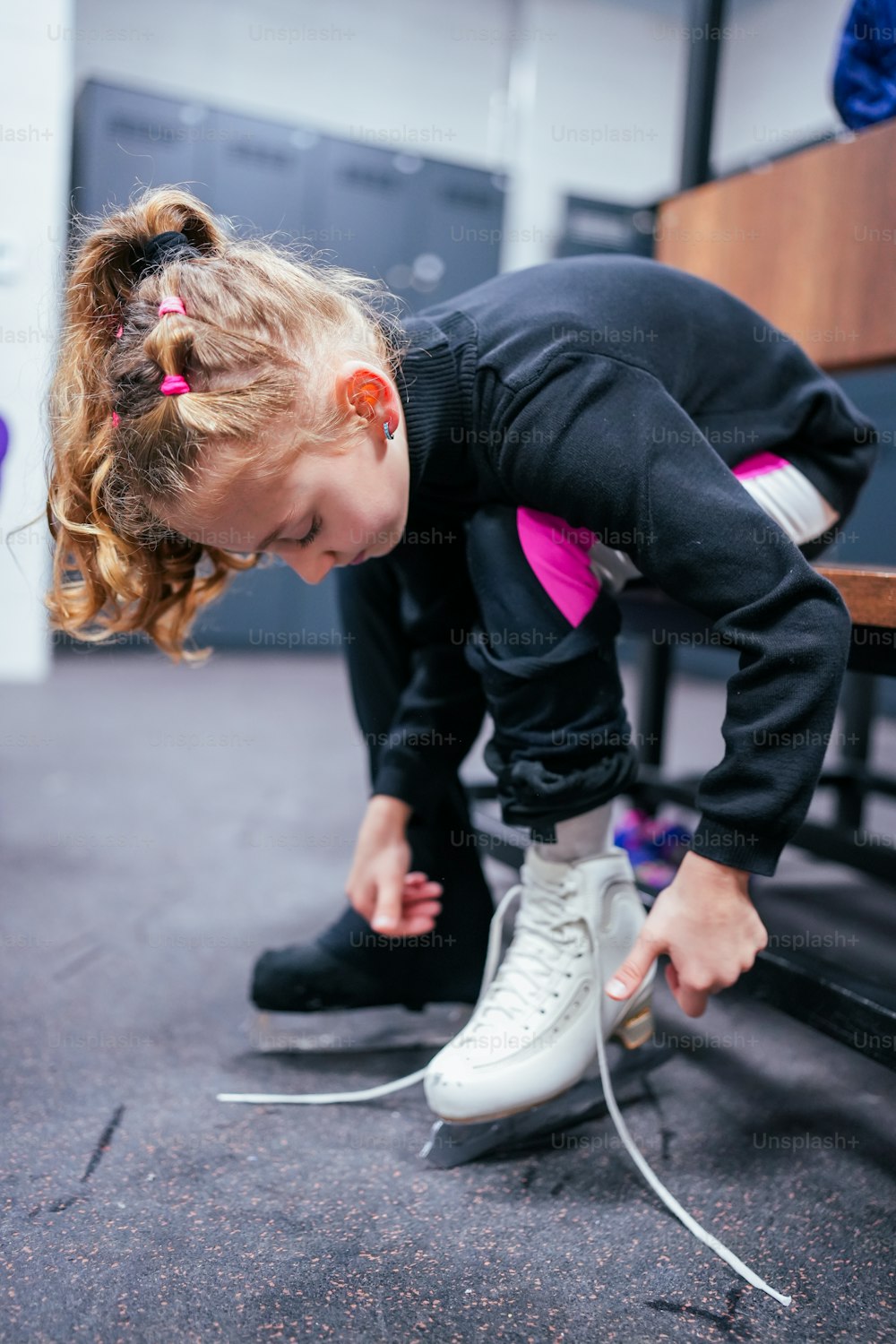 a young girl tying up her tennis shoes