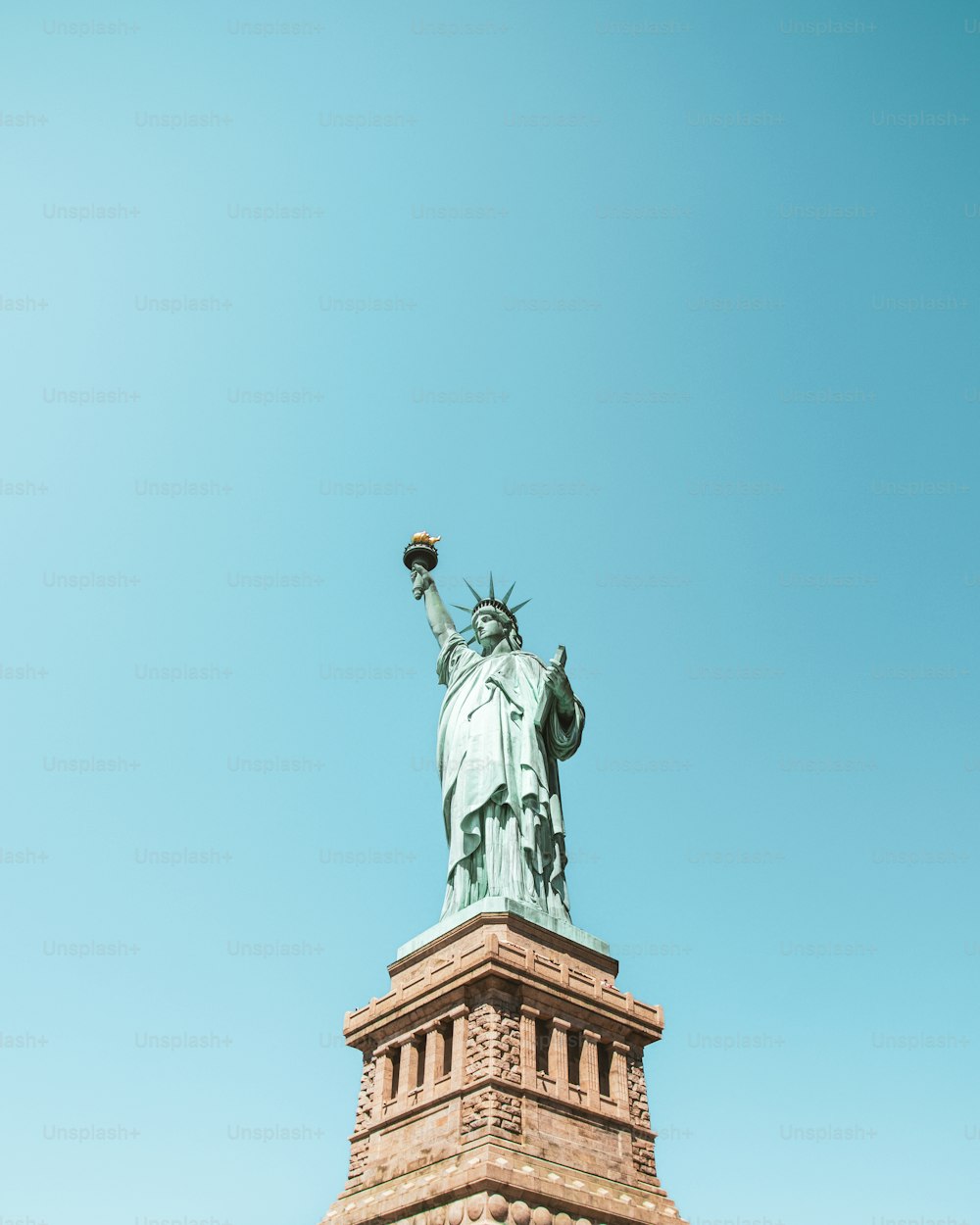 the statue of liberty is shown against a blue sky