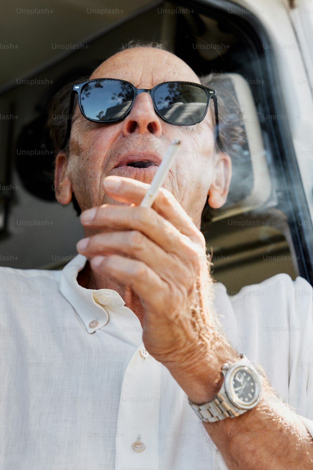 Ein Mann raucht eine Zigarette vor einem Lieferwagen