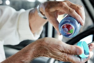 an older person holding a cup in their hand