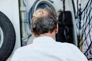the back of a man's head in front of a tire