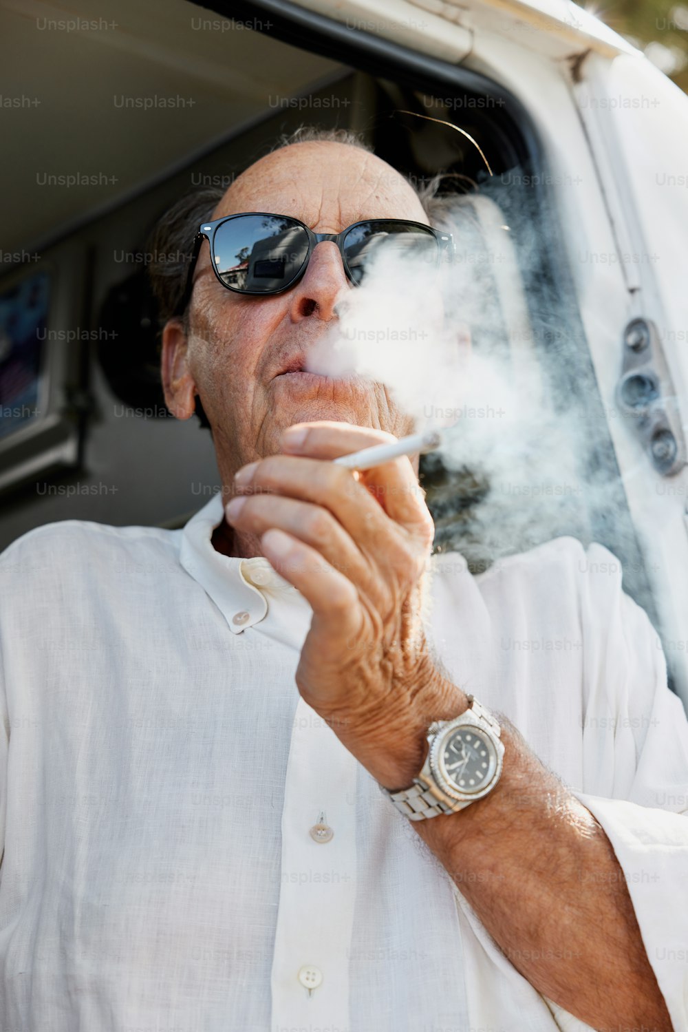 Ein Mann raucht eine Zigarette vor einem Lieferwagen