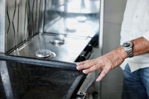 um homem segurando uma porta de forno preta