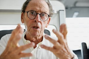 an older man wearing glasses and a white shirt