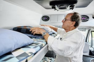 a man in a white shirt is putting a blanket on a bed