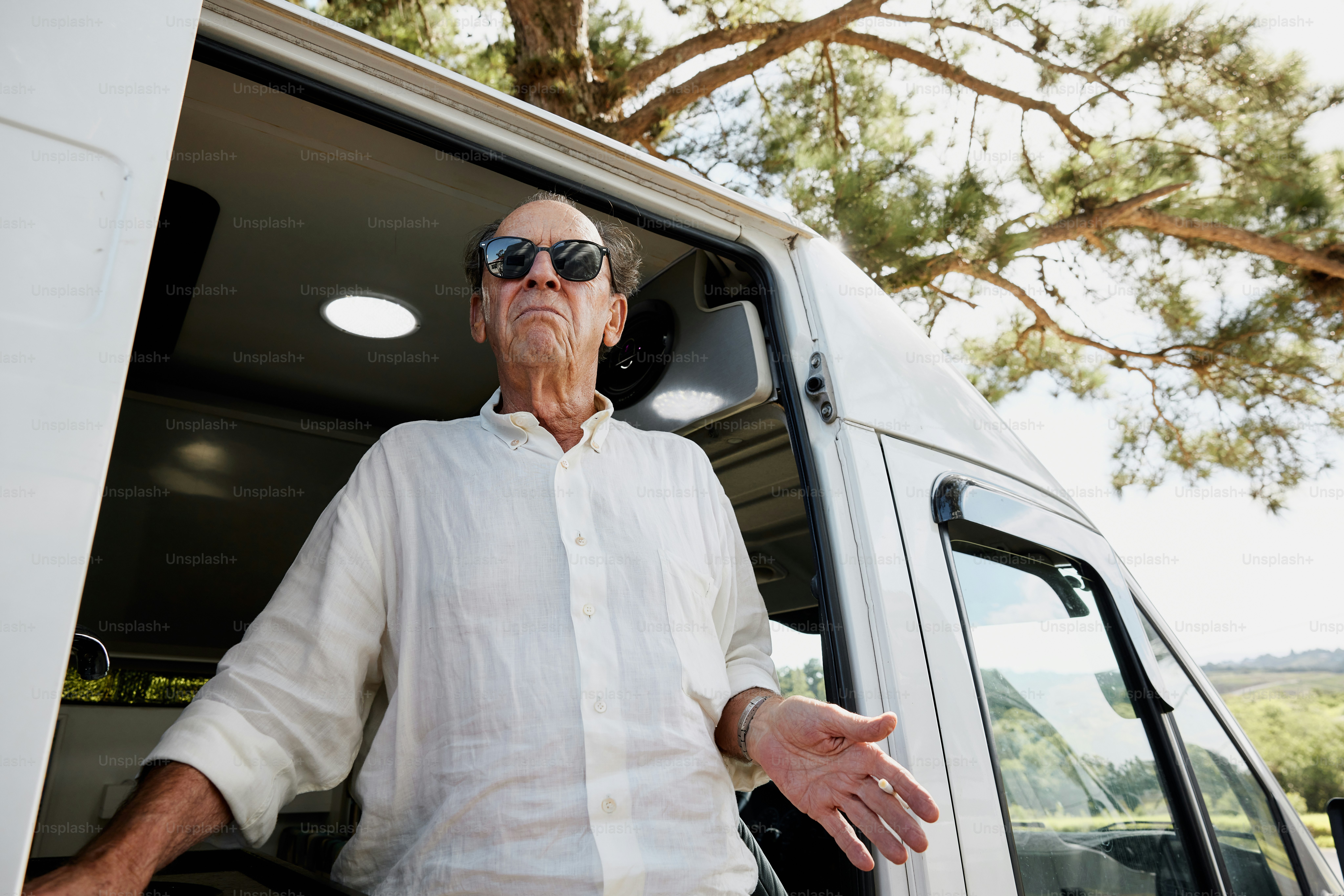 Un hombre con gafas de sol parado en la parte trasera de una camioneta