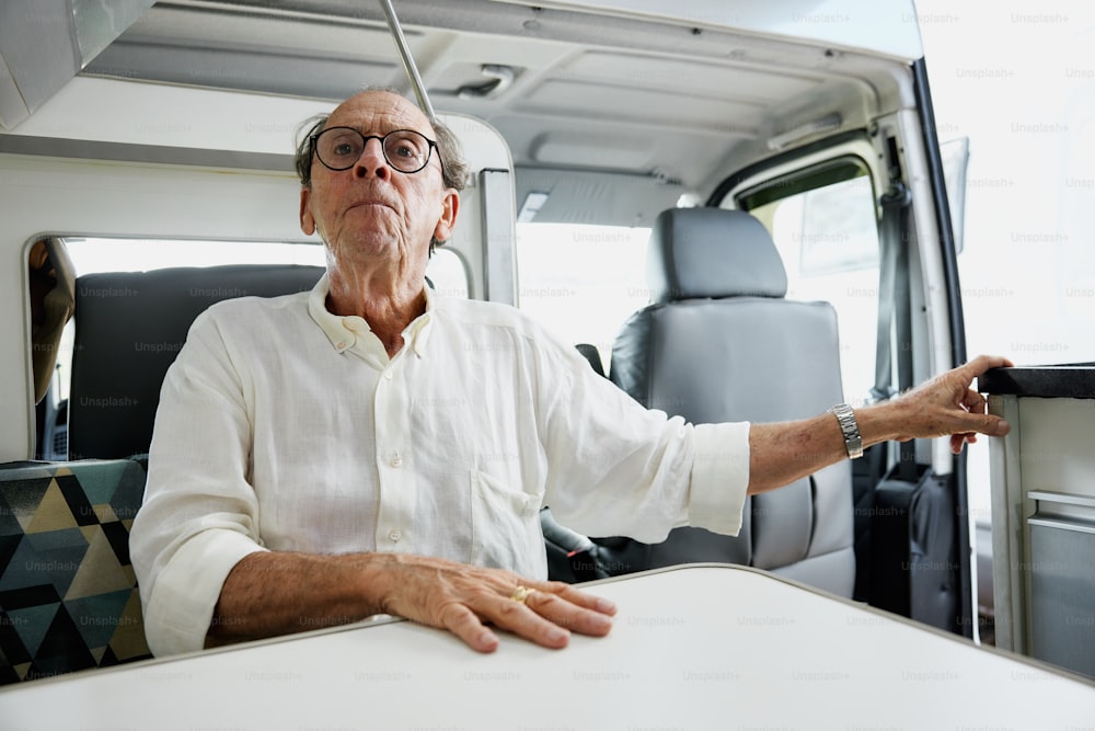 a man sitting at a table in front of a van