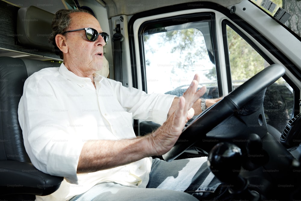 Un hombre con una camisa blanca conduciendo un camión