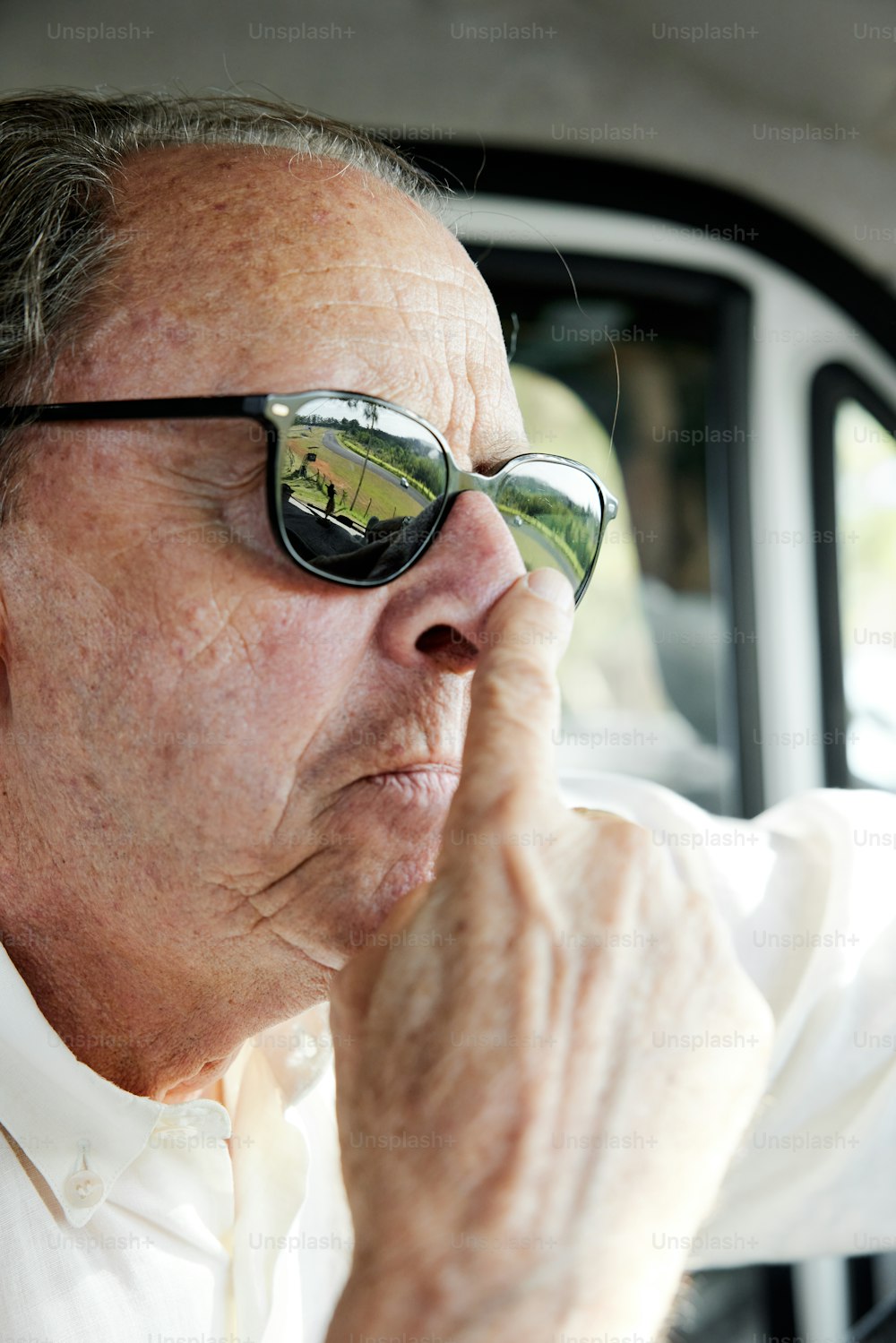 a man wearing sunglasses sitting in a car