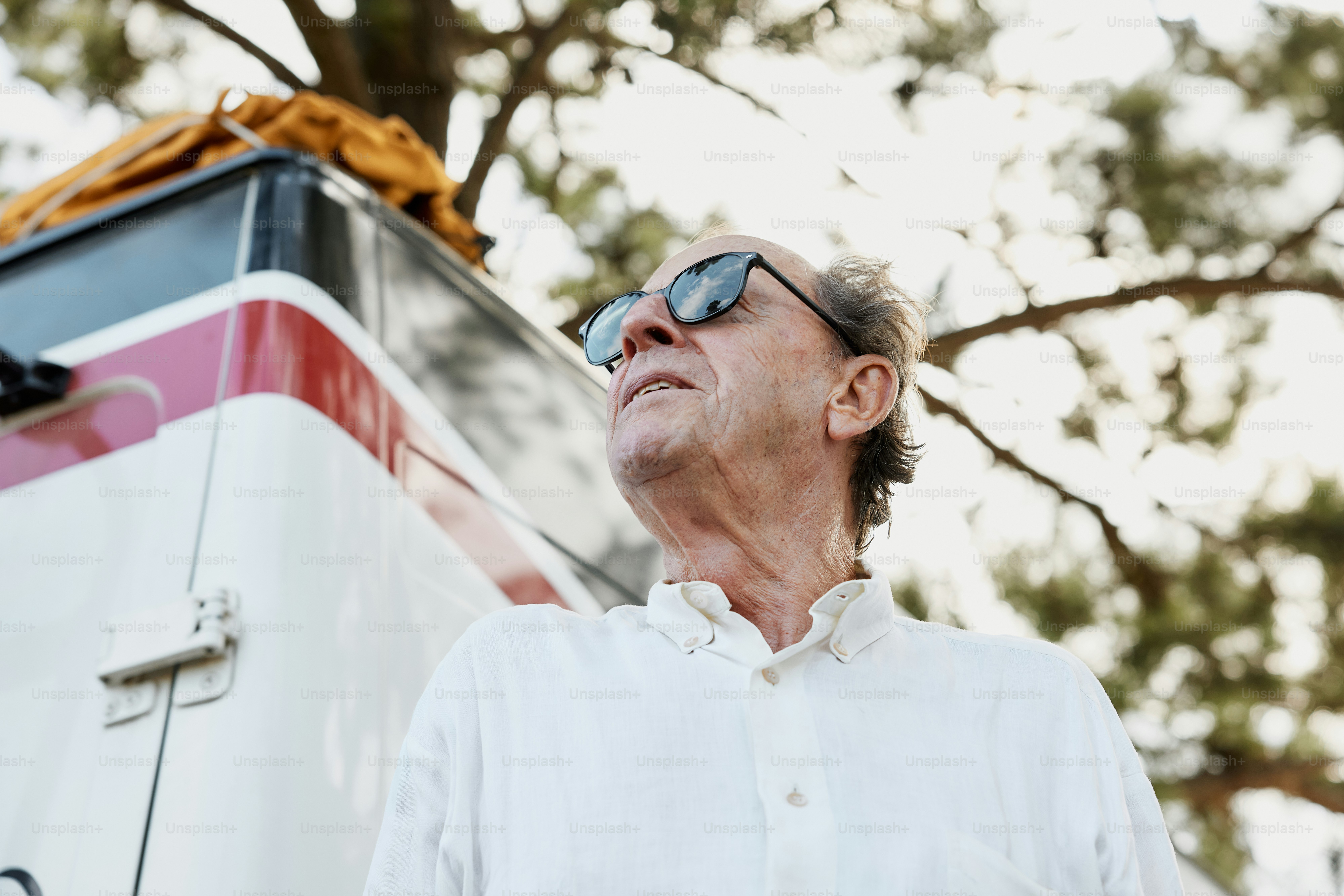 Un hombre con gafas de sol parado frente a un autobús