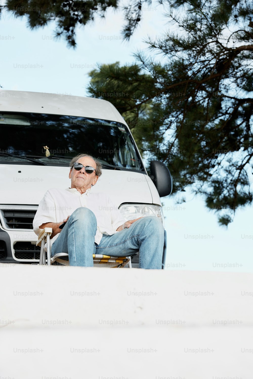 a man sitting in a chair next to a van