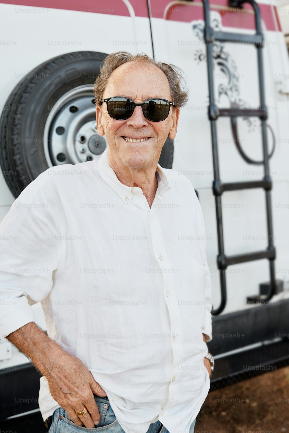 a man wearing sunglasses standing in front of a truck