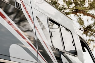 the side of a bus with a tree in the background