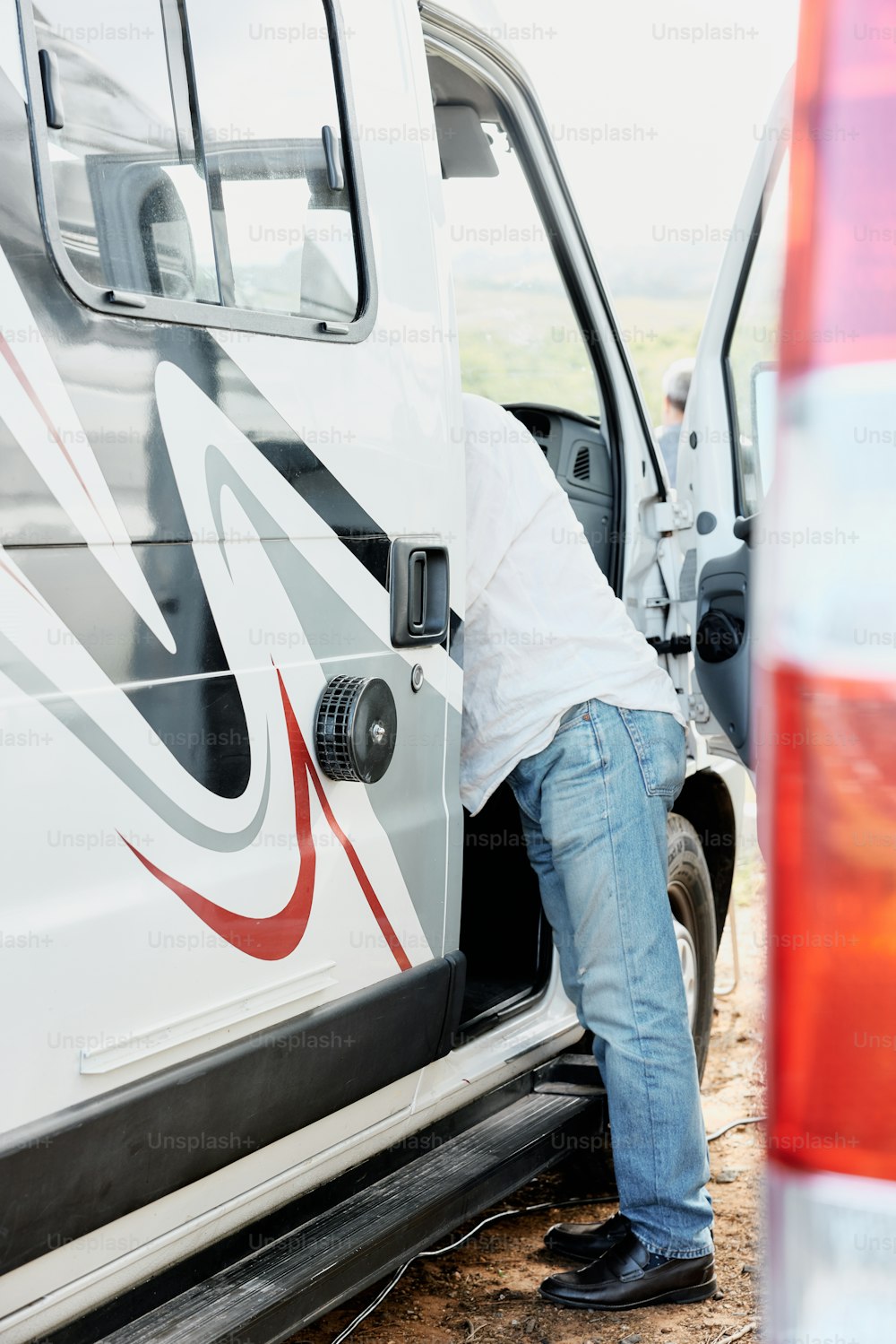 a man leaning against the door of a van